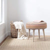 Veranda Natural Indoor/Outdoor Rug styled under baskets and stool. Styled view. 