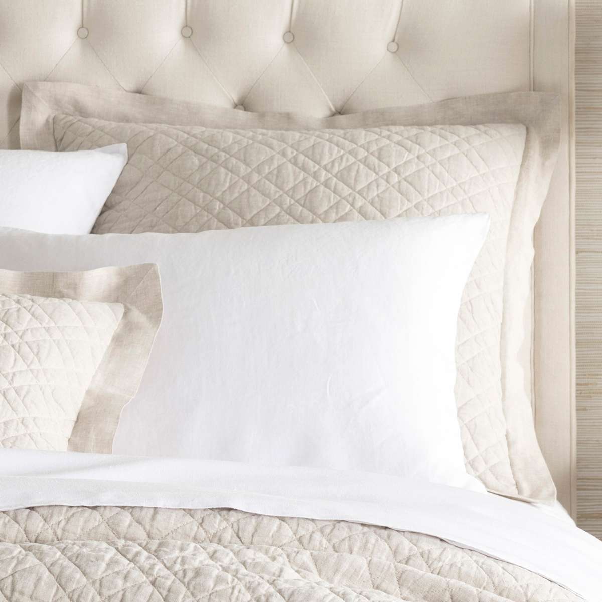 Washed Linen Natural Quilted Sham styled with white sheets. Styled view. 