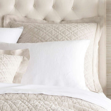 Washed Linen Natural Quilted Sham styled with white sheets. Styled view. 