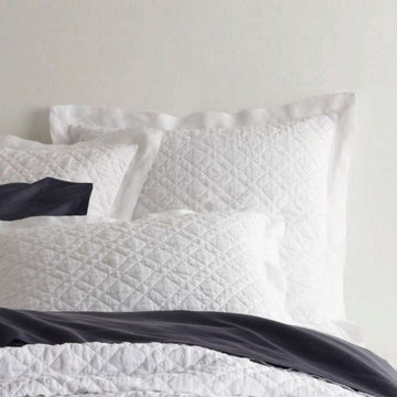 Washed Linen White Quilted Sham styled with navy sheets. Styled view. 